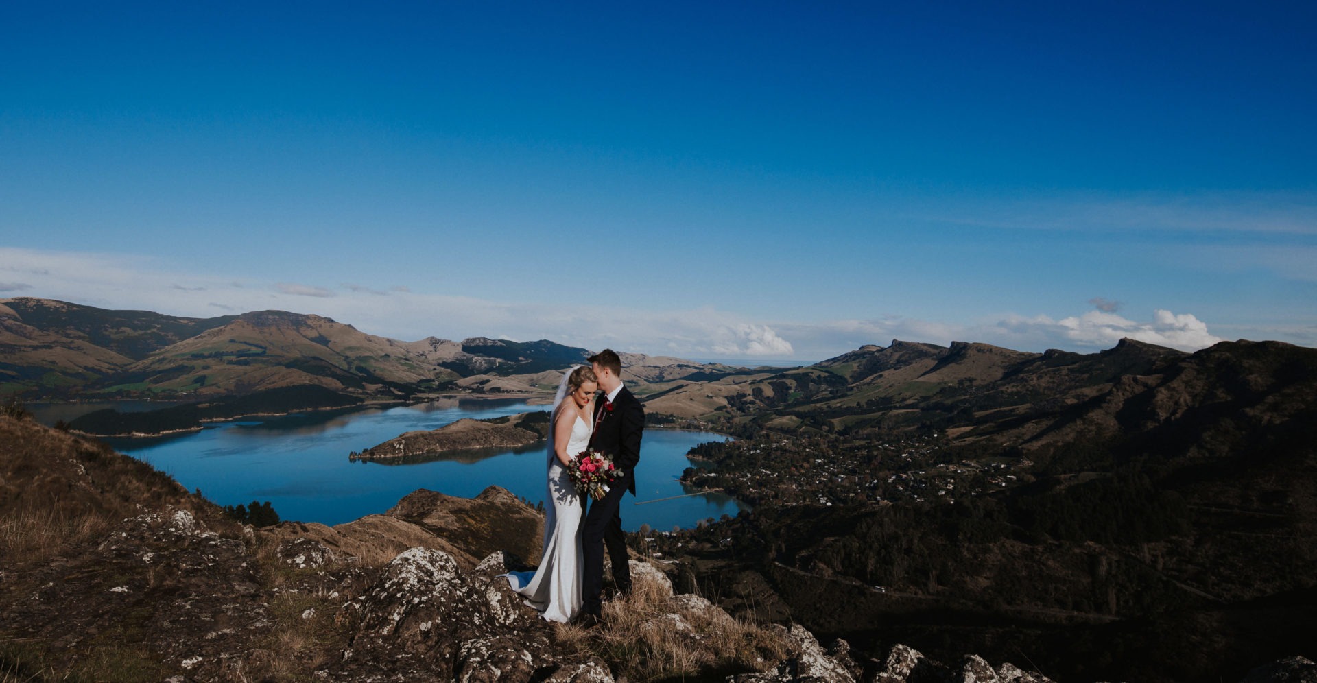 Bride and Groom on top of mountains with lake in background - Wedding Photography by Tracey Allsopp