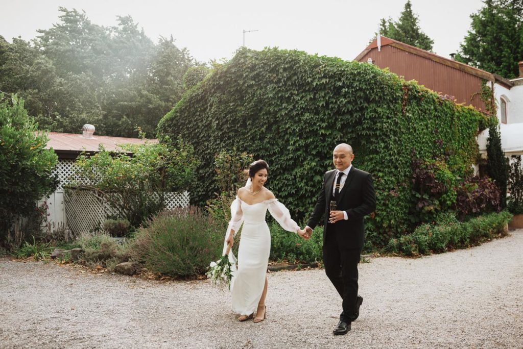 Bride and Groom walking hand in hand around wedding venue. Photo taken by Tracey Allsopp Photography 