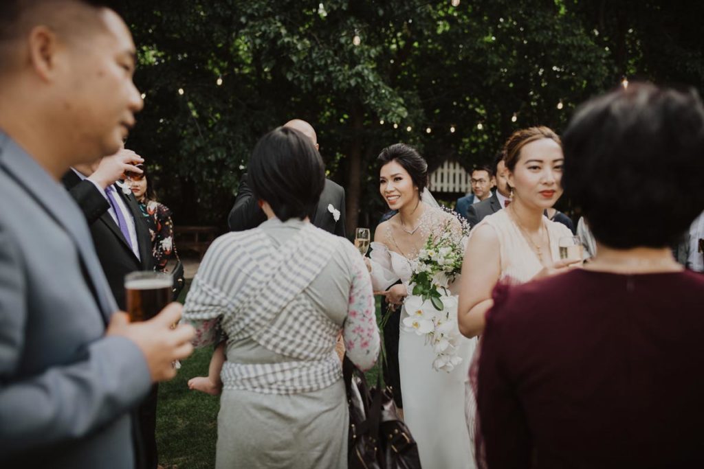 Bride and Groom mingling with guests after the ceremony and sipping champagne. Photo taken by Tracey Allsopp Photography 